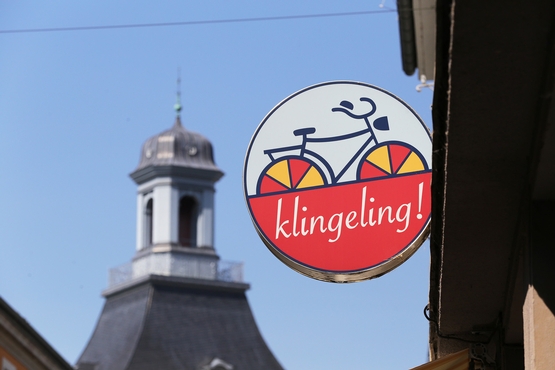 Das Schild von klingeling! Im Hintergrund ist einer der Türme der Bonner Universität zu erkennen.