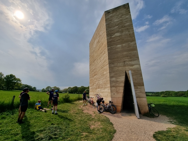 Mehrere Radfahrer rasten an der Bruder Klaus Kapelle.