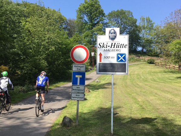 Eine Aufnahme von einem Schild, welches die Richtung zu einer Ski-Hütte zeigt