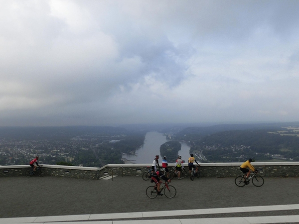 Mehrere Fahrradfahrer blicken auf den Rhein hinab.
