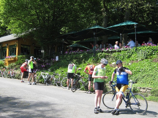 Mehrere Fahrradfahrer machen Pause vor einem Biergarten.