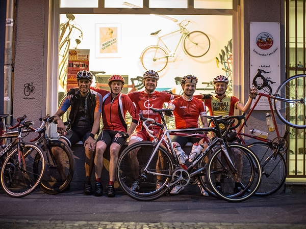 Mehrere Fahrradfahrer sitzen und posieren vor klingeling.
