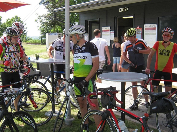 Mehrere Fahrradfahrer stehen vor einem Kiosk.