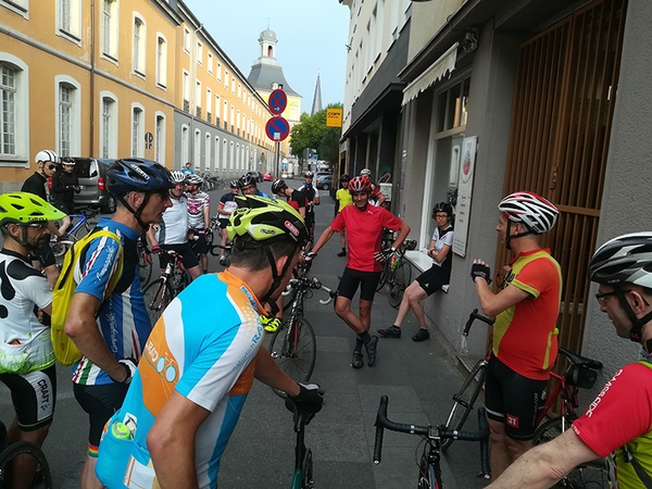 Mehrere Fahrradfahrer stehen an der Straße.
