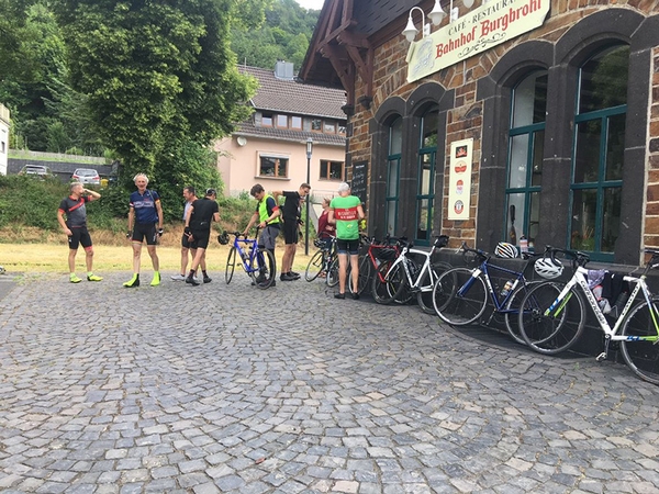Mehrere Fahrradfahrer stehen vor einem Restaurant.