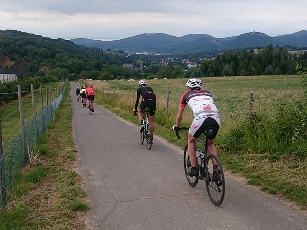 Mehrere Fahrradfahrer fahren einen Feldweg entlang.
