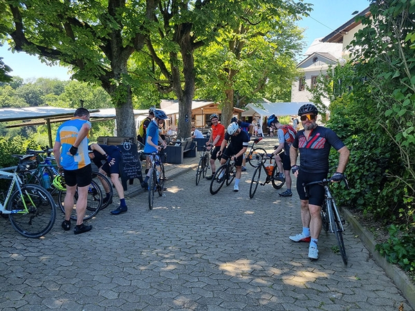 Mehrere Fahrradfahrer machen vor einem Imbiss Pause.
