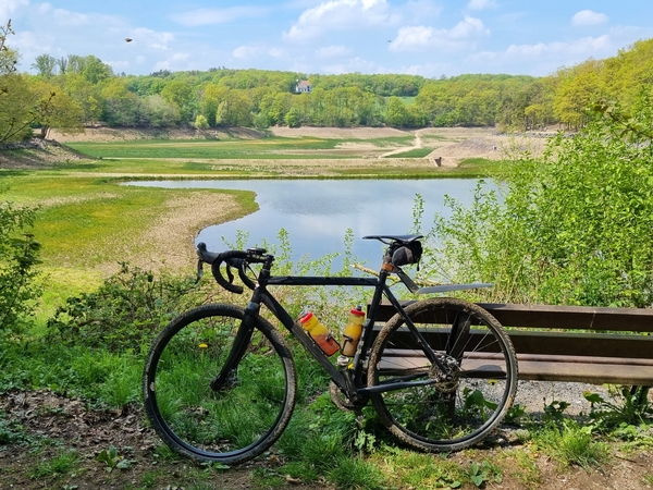 Ein Fahrrad lehnt an einer Bank, im Hintergrund die Steinbachtahlsperre